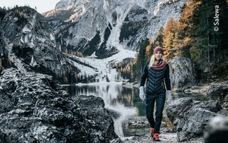 Wanderin mit Isolationsjacke an einem Bergsee