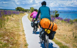 Radfahrer mit Gepäck fahren an einem See entlang