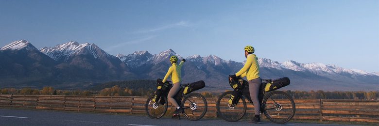 Fahrradfahrer beim Bikepacking vor Bergkulisse