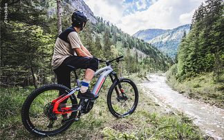 Mountainbiker mit einem E-Bike Fully in den Bergen.