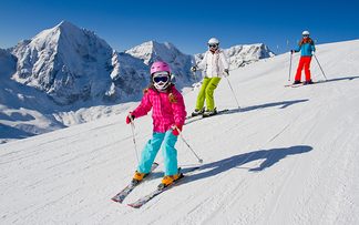 Familie mit Ski im Schnee